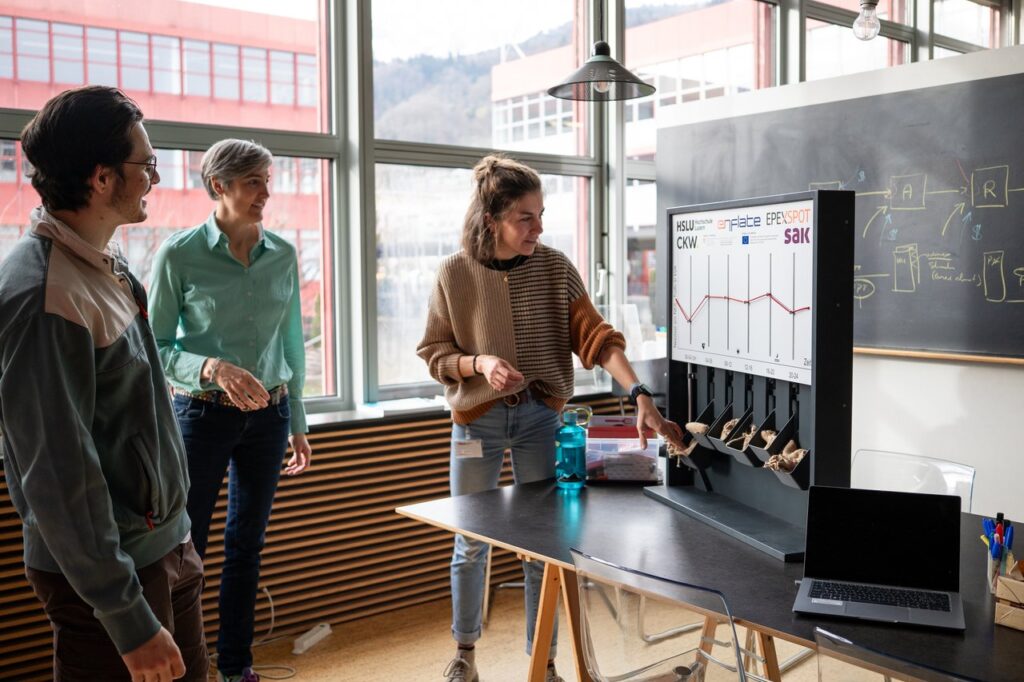 Forschende des CC Business Engineering diskutieren die Flexibilisierung des Strommarktes am Modell.