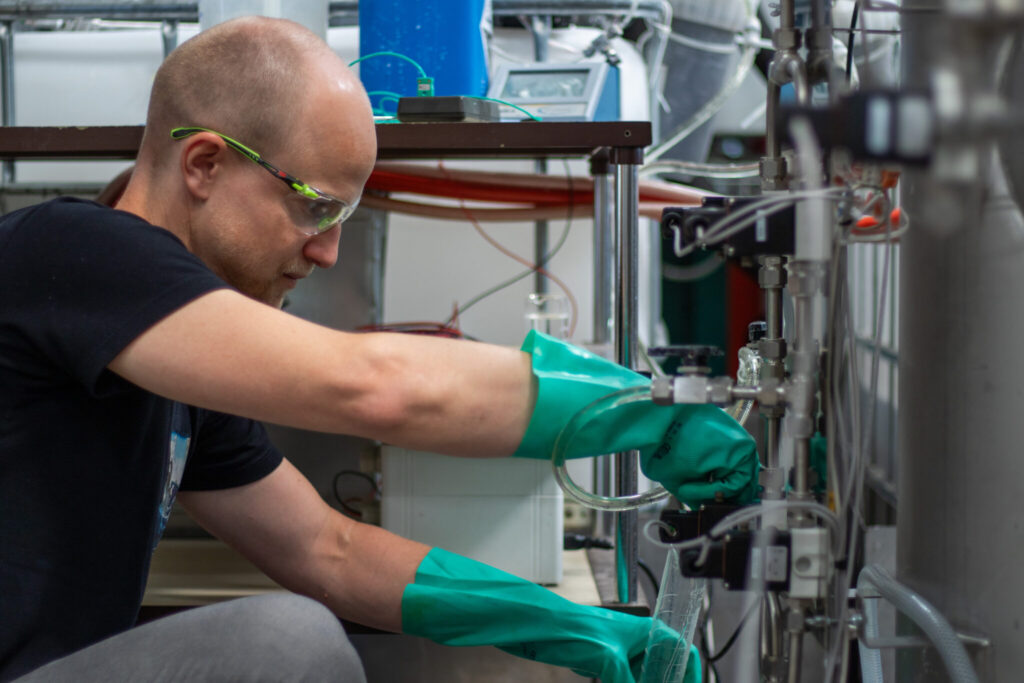 Mathias Müller prüft den Versuchsaufbau der Sorptionsspeicher-Wärmepumpe SeasON im Labor der HSLU – T&A.